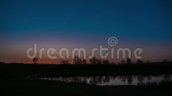 随着时间的推移太阳升起在田野上从一夜到一天湖面上黎明视频的预览图