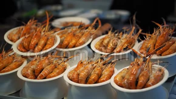 在他们的盘子里放着美味的红制虾亚洲传统食品市场的虾菜视频的预览图
