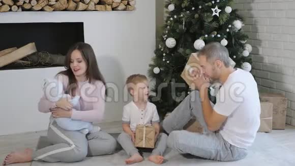 一家人在树旁打开圣诞礼物视频的预览图