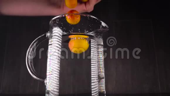 把水果泼在水里慢运动的杏落在有水的容器里带水果的美丽框架视频的预览图