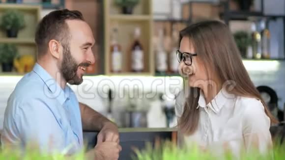 欧洲的男人和女人笑着坐在酒吧里举行非正式会议视频的预览图