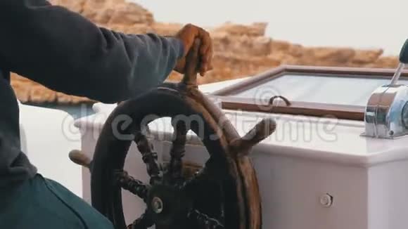船长在靠近岩石的海上风暴中控制着旅游游艇游艇的方向盘视频的预览图