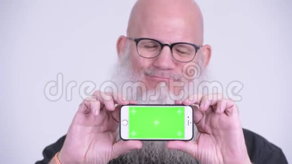 一脸快乐成熟的秃头男人一边看手机一边思考视频的预览图