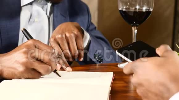 商业概念近距离拍摄美国黑人男性手在桌子上背景上有一个火的地方商务视频的预览图