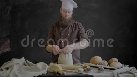 厨师检查面粉的质量站在一张用面包店的糕点装饰的桌子附近视频的预览图