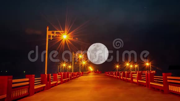 在泰国的普拉查普湾桥上的灯光和夜空中的满月迅速升起视频的预览图