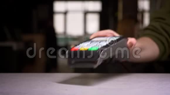 人通过终端机刷卡完成支付的特写镜头视频的预览图