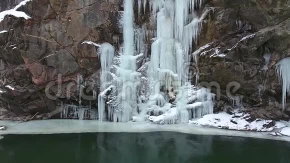 岩石上的冰冻瀑布峡谷底部的冬季景观视频的预览图