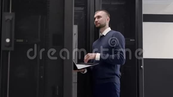 管理员在服务器机房行走在笔记本电脑上打字视频的预览图