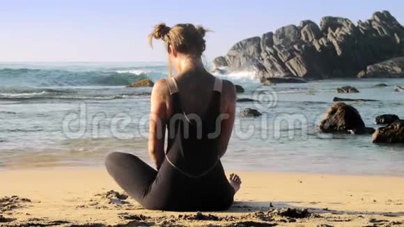 美丽的女士在沙滩上和海洋做冥想视频的预览图