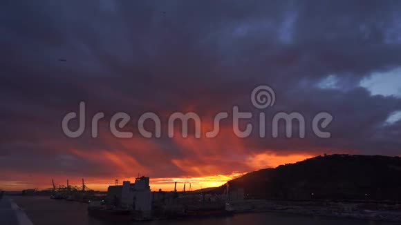 日落时分深蓝紫红的风暴天空背景伴随着巴塞罗那海岸线上令人惊叹的生机勃勃的云团视频的预览图