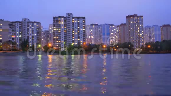 位于湖边的公寓建筑日落时紫色的天空映在水中夜景视频的预览图