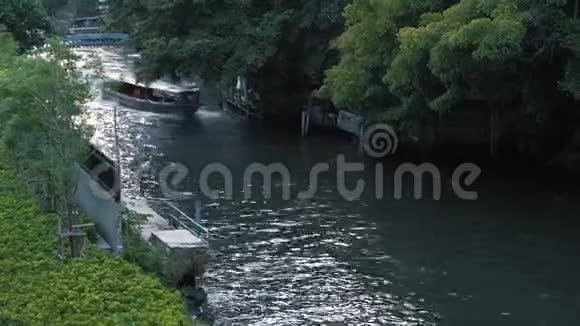 夏天小船在绿树之间的城市航道上漂浮城市水路交通视频的预览图