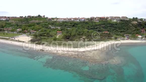 鸟瞰绿松石令人叹为观止的海滩下的一个旅游村阿西托斯Halkidiki希腊向后移动无人机视频的预览图