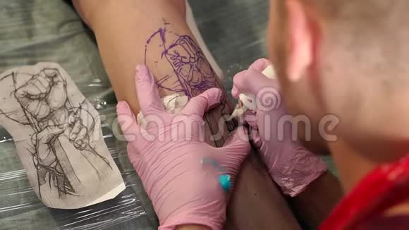 在纹身工作室做纹身的师傅男人在女孩腿上做纹身视频的预览图