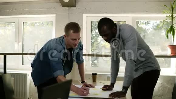 两个商人指着桌子桌子上有黄色的文件和商务会议上的铅笔他们是视频的预览图