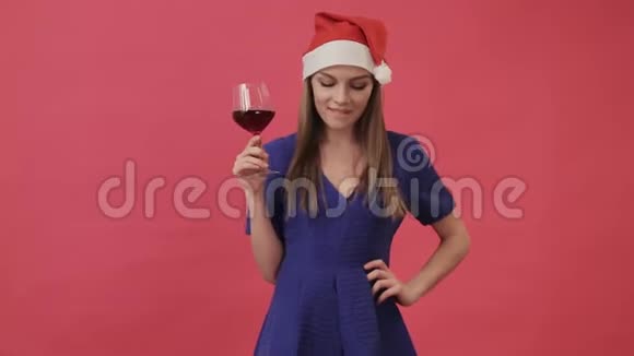 穿圣诞衣服的漂亮女孩手里拿着一杯酒跳舞工作室粉色背景视频的预览图