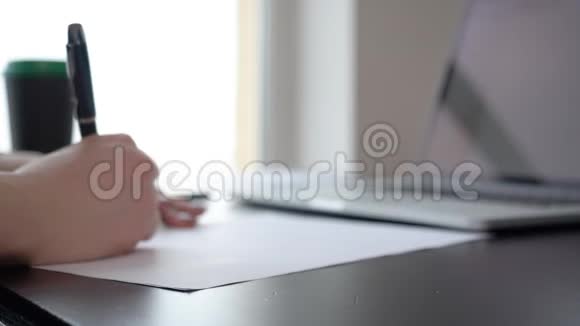 妇女用螺旋记事本在木制桌面上写字的特写镜头视频的预览图