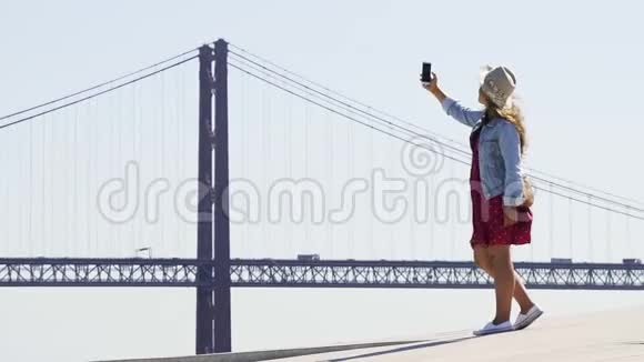 年轻女孩在著名的桥后自拍视频的预览图