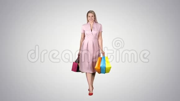 购物女人拿着购物走到镜头前的渐变背景视频的预览图