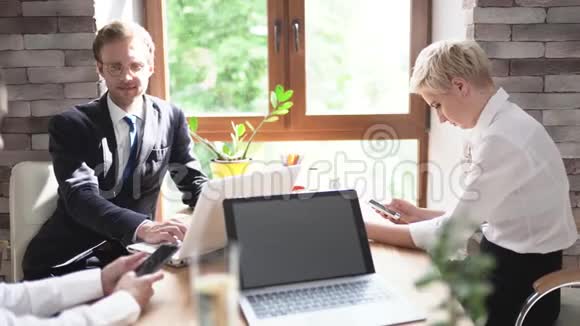 案件的同事男女在开完一次业务会议后坐在办公桌前视频的预览图