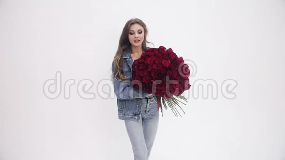 有魅力的女人拿着一束红玫瑰拍照视频的预览图