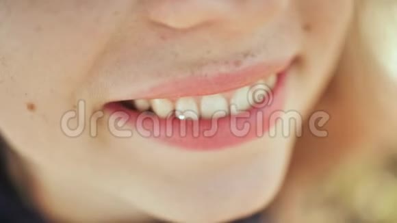 年轻女孩带着钻石在牙齿上微笑牙齿上的天空牙齿钻石穿孔视频的预览图