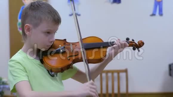 在学校的音乐课上小学生正在拉小提琴视频的预览图