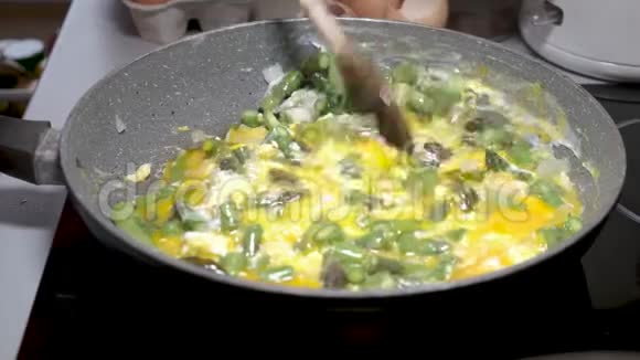 鸡蛋和洋葱煎锅中的绿芦笋视频的预览图