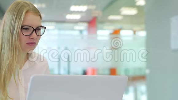 这个女孩在办公室工作买一台笔记本电脑享受一份完美的工作视频的预览图