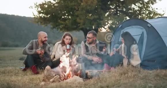篝火时间一群朋友在野餐时搭帐篷一个年轻的家庭和他们的孩子一起玩耍视频的预览图