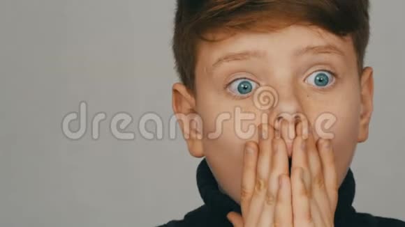 一个金发碧眼的少年男孩的肖像在白色背景的镜头前感到惊讶选举的影响视频的预览图