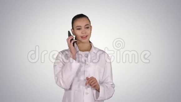 微笑的女医生在电话交谈而走在梯度背景视频的预览图