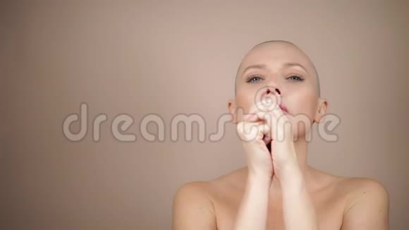 秃头的女人在祈祷时双手交叉米色背景视频的预览图
