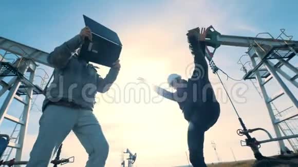 两个快乐的工程师跳舞在油田上玩得很开心视频的预览图