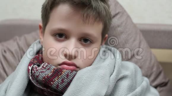 一个冷漠的男孩悲伤地看着镜头他得了流感视频的预览图