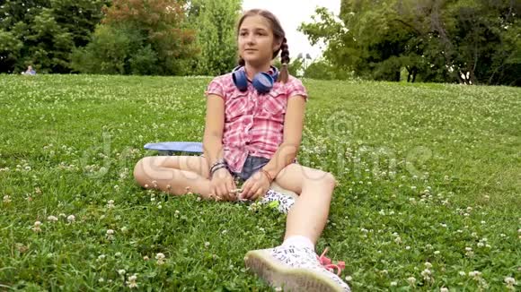 可爱的少女坐在草地上视频的预览图