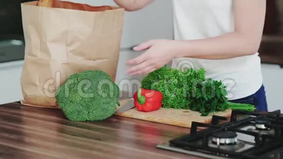 现代厨房的女性拆包杂货店购物袋和蔬菜的特写视频的预览图