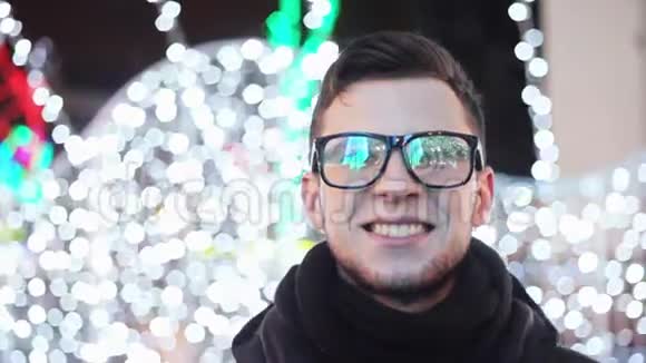时尚的年轻人看着主城的圣诞树眼镜里反射着灯光视频的预览图