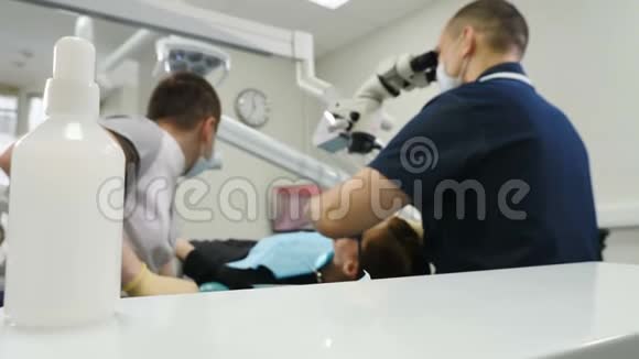 拍摄牙医工具包的第一个计划和模糊病人坐在牙科椅的背景医生治疗女性视频的预览图