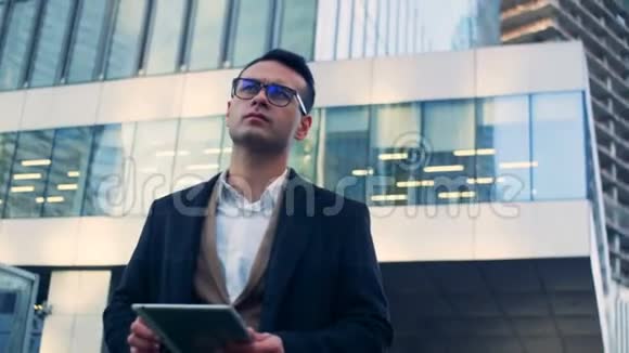 办公室摩天大楼和一个男性商人成功的经理站在市中心红色史诗龙6K射击视频的预览图