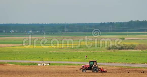 拖拉机在温暖的春日季节犁田开始农业春季季节拖拉机牵引的耕地视频的预览图