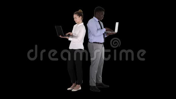 两人背靠背站着在笔记本电脑上工作阿尔法频道视频的预览图