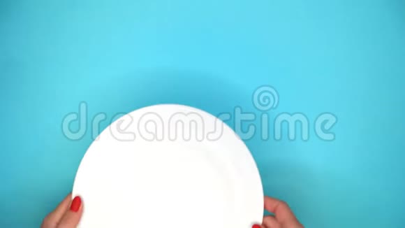 女人手把桌子放在餐馆里吃午饭或晚餐服务员把白色盘子和刀子放在蓝色的表面视频的预览图
