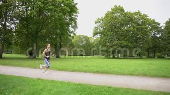 绿色公园里跑步的女青年视频的预览图