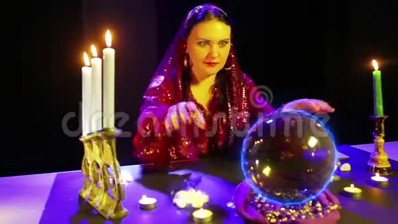 在魔术沙龙里的吉普赛人用水晶球做魔术从水晶球里发出电光视频的预览图
