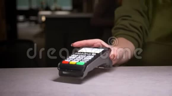 人的特写镜头将信用卡插入终端并输入执行支付的引脚代码视频的预览图
