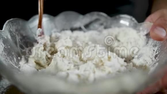 混合面粉和面团用木勺在黑暗的背景上烤蛋糕视频的预览图