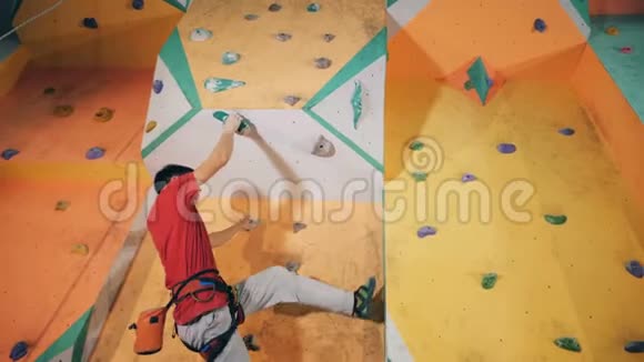 人挂在健身房的攀岩墙上底景视频的预览图