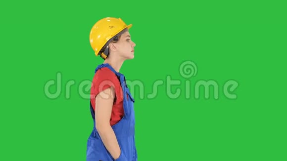 建筑工人女士在绿色屏幕上无感情地行走Chroma键视频的预览图
